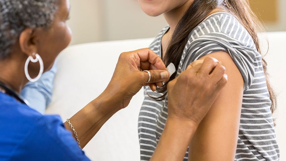 A young person getting a jab