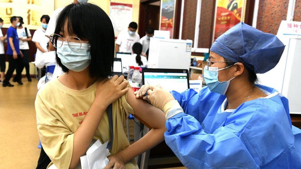 Ученик получает дозу вакцины COVID-19 в средней школе Pingdong 30 июля 2021 года в Фучжоу