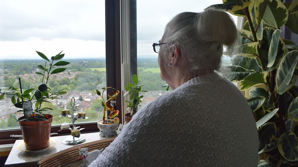 Pat enjoys the view from her tower block window
