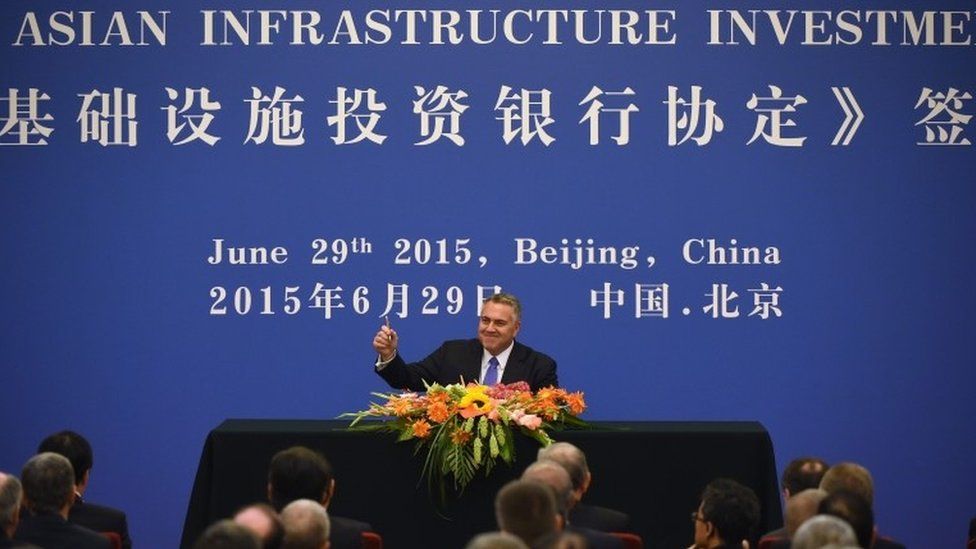 Australia's Treasurer Joe Hockey (C) holds up his pen as he becomes the first to sign an articles of association to help set up the Asian Infrastructure Investment Bank (AIIB) during a ceremony at the Great Hall of the People in Beijing on June 29, 2015.