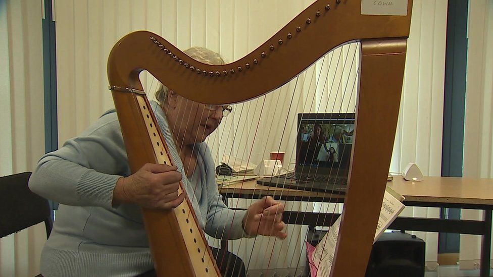 Elinor Bennett with harp and laptop