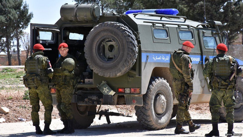 Members of the Russian military police stand guard in the northern city of Manbij