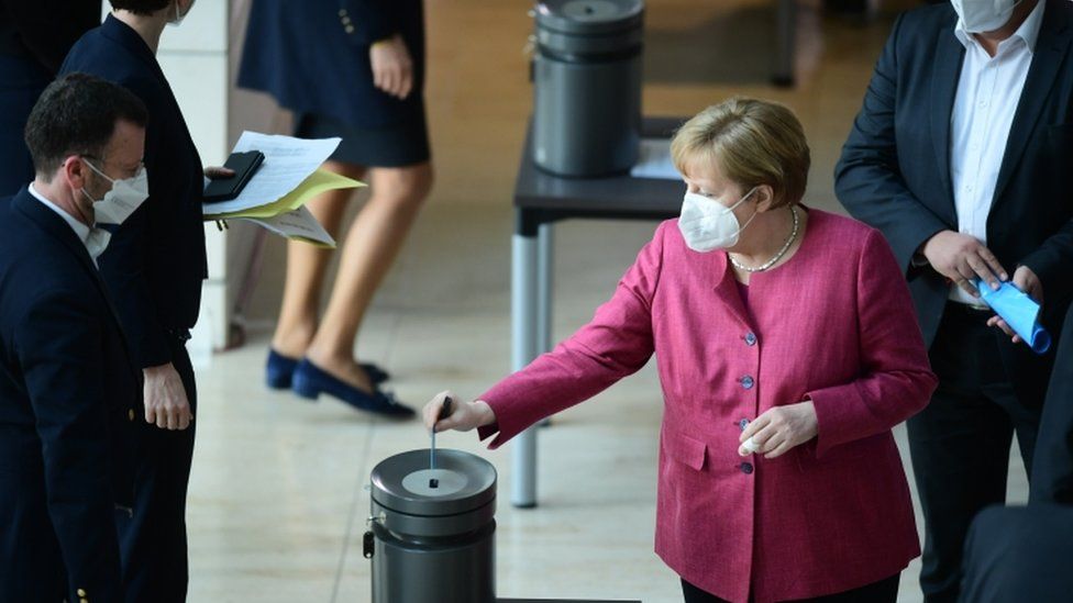 Канцлер Германии Ангела Меркель опускает свой бюллетень для окончательного голосования по Закону о защите от инфекций во время заседания Бундестага парламента Германии в Берлине, Германия, 21 апреля 2021 г.