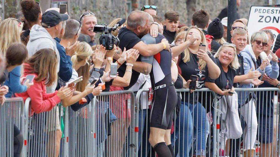 Gareth Thomas is embraced by his husband Stephen at the Ironman triathlon in Tenby, Pembrokeshire