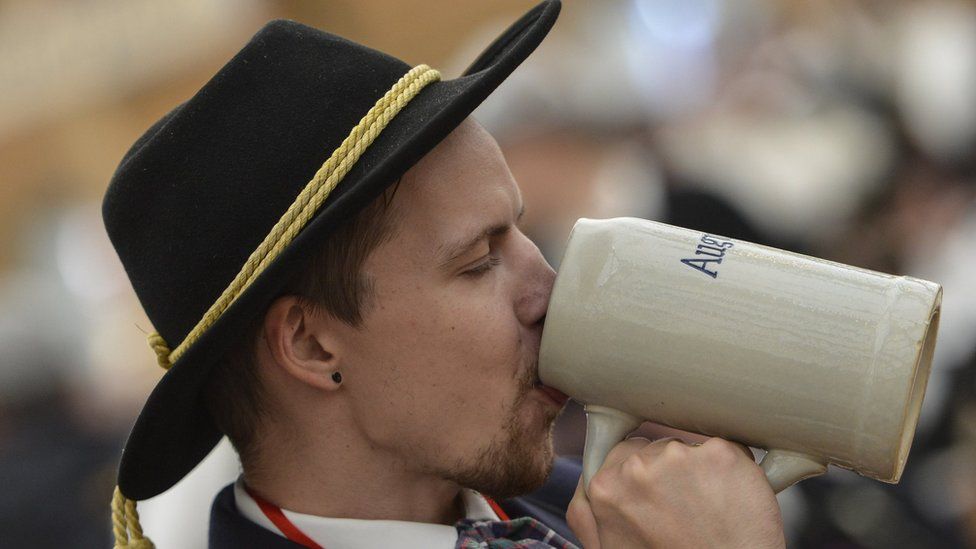 A man in traditional Bavarian clothing enjoys beer at the Oktoberfest on September 20, 2015 in Munich, Germany.