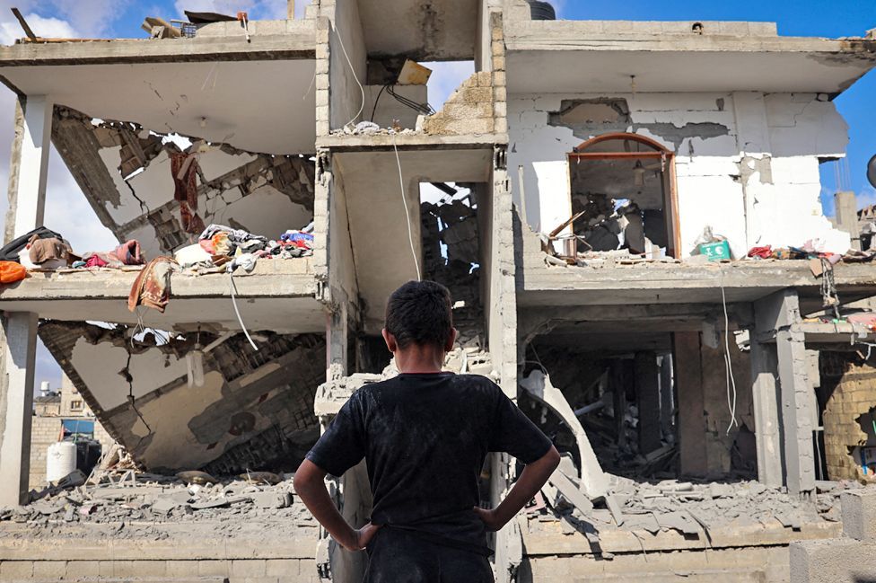 A Palestinian youth stands in front of a destroyed building following Israeli bombardment of Rafah's Tal al-Sultan district in the southern Gaza Strip on 7 May 2024