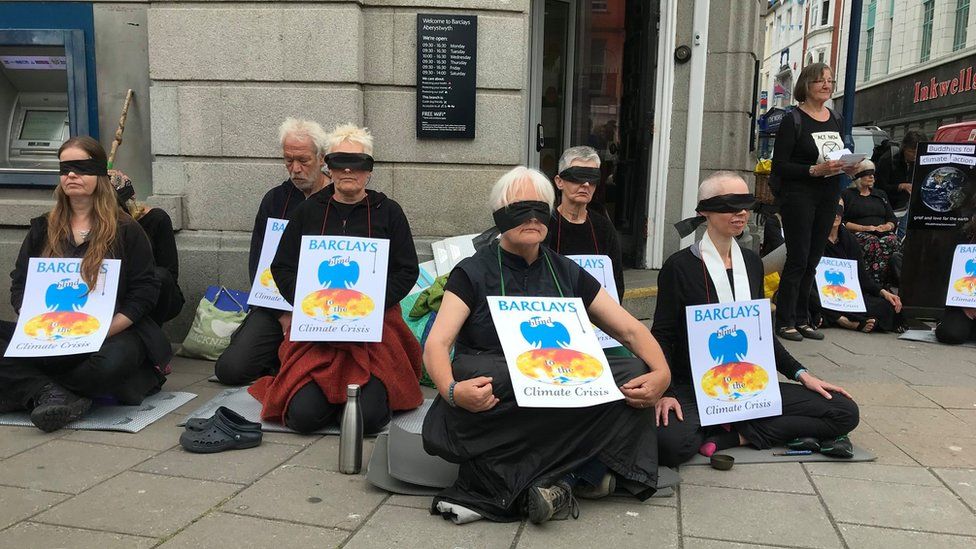 Protesters sat outside the Aberystwyth branch wearing blindfolds