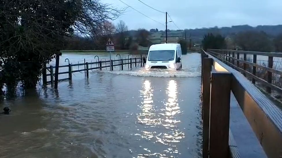 Van driving through a flooded lane