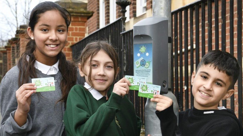 Primary school children tapping their cards against beat boxes