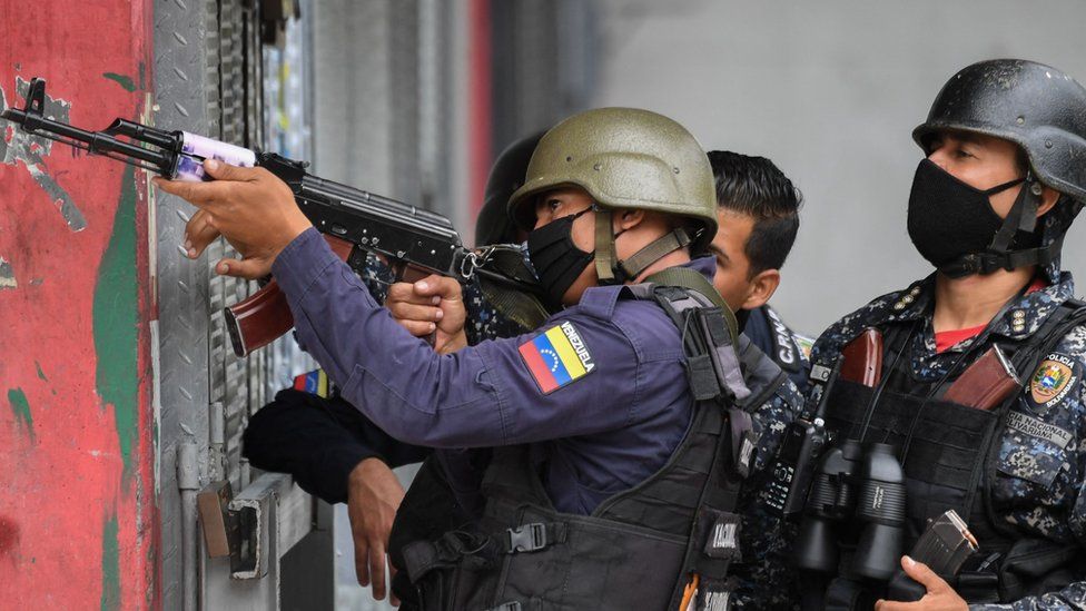 Members of the Bolivarian National Police aim at possible targets after clashes with alleged members of a criminal gang at the Cota 905 neighbourhood in Caracas on July 9, 2021