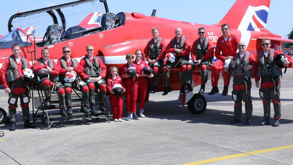 Blue Peter competition winners in front of an RAF aircraft with Red Arrows pilots