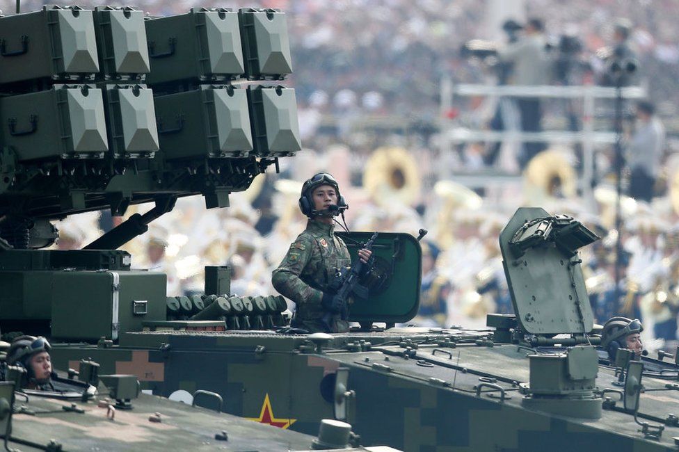 A soldier of the People's Liberation Army stands to attention on a tank during a parade to celebrate the 70th anniversary of the founding of the People's Republic of China in 1949, at Tiananmen Square in Beijing on 1 October 2019.