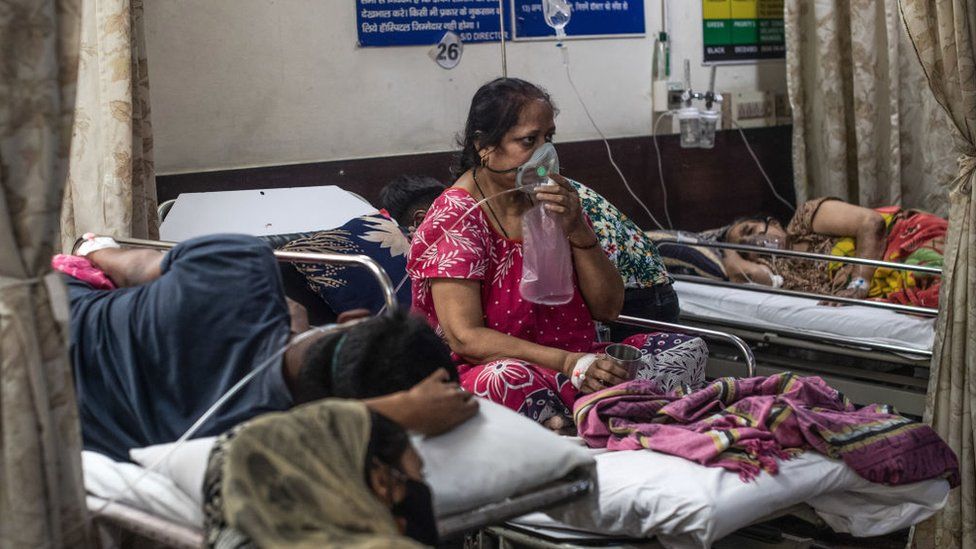 A woman who contracted the coronavirus sits connected to oxygen supply inside the emergency ward of a Covid-19 hospital on May 03, 2021 in New Delhi, India