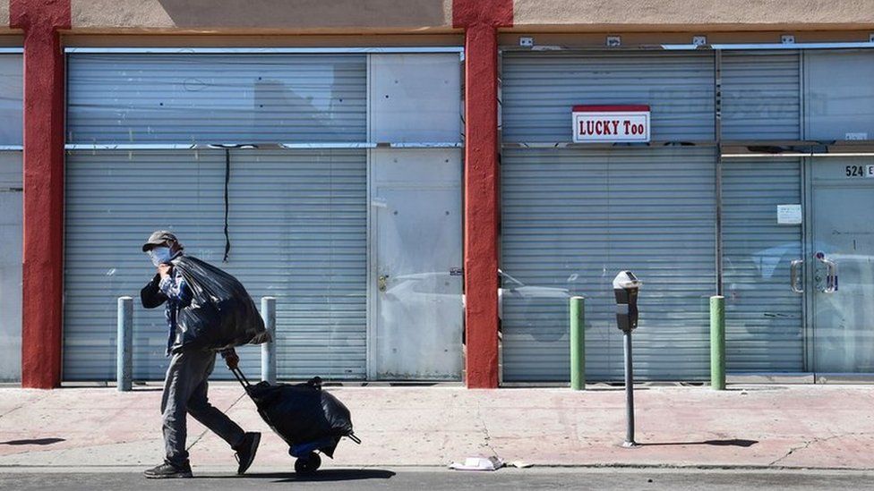 man walks past closed stores in US
