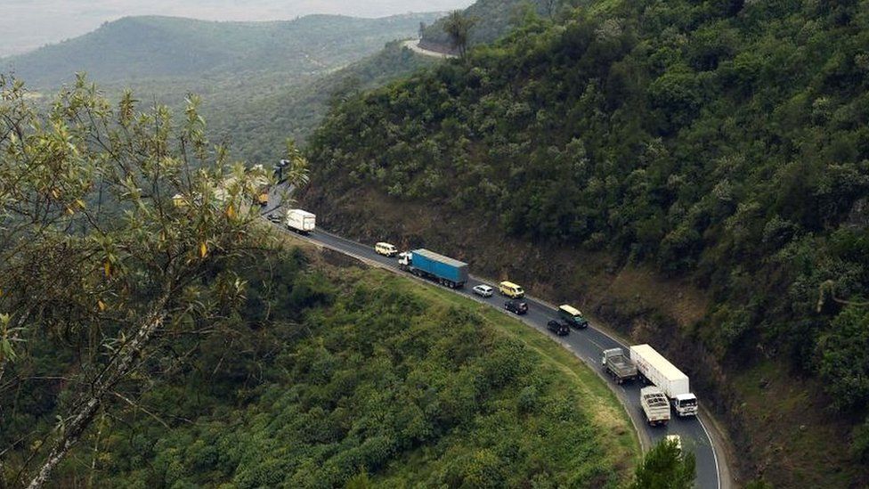 Trucks and cars drive on a section of a road leading down the eastern escarpment of Kenya's Rift Valley.