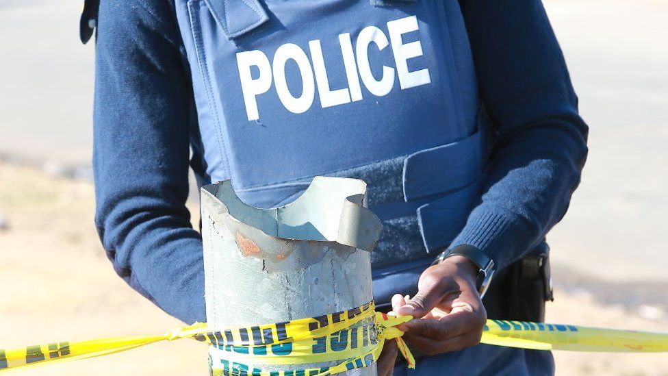 Police officer tying a crime scene tape