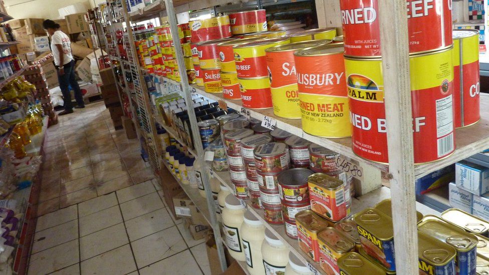 Cans of imported corned beef and other processed meat on a supermarket shelf in Tonga