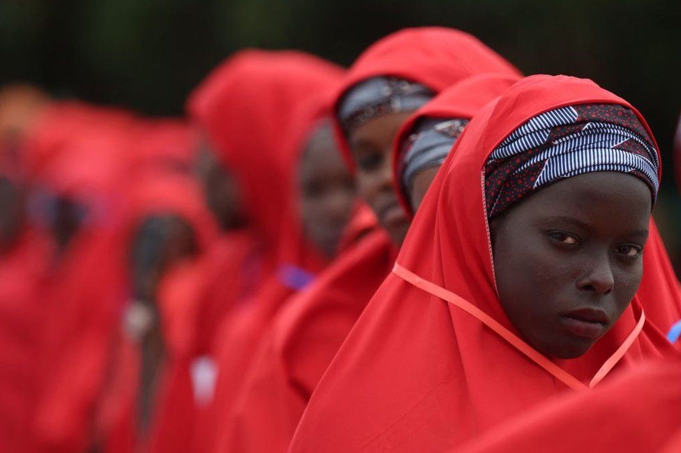 A bride dressed in red robe, looks on at the venue of a wedding reception at the Kano state governor's office after taking part in a mass wedding at the central mosque in Kano city, Kano State, Nigeria on October 14, 2023. The mass wedding is sponsored by the Kano State government in Nigeria to help widows and divorcees get remarried.