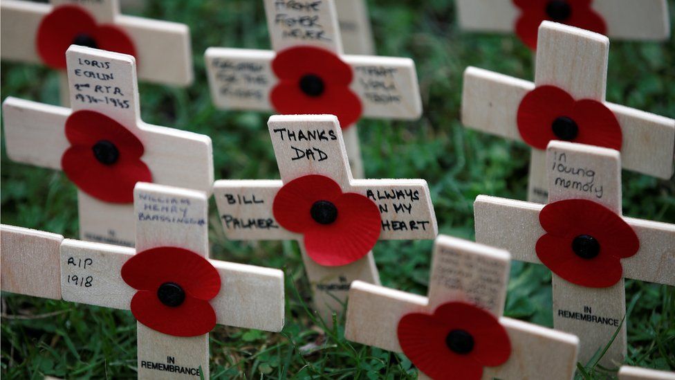 Poppies attached to wooden crosses are laid in a field of remembrance next to Westminster Abbey