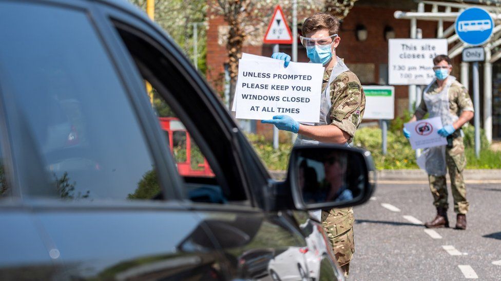 Soldiers give instructions to people in a vehicle at the mobile COVID-19 testing unit, amid the coronavirus disease (COVID-19) outbreak in Salisbury, Britain