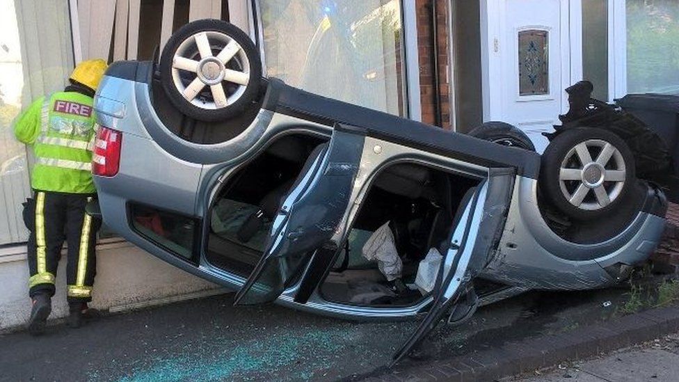 Overturned car crashed into shop front