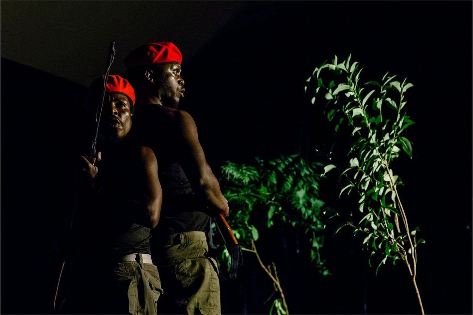 Actors play two red berret soldiers with assault rifles searching for innocent civilians who have deserted their homes hiding in the thick bush on June 2, 2018, in Harare, as they take part in a scene from a play "1983 the Dark Years", which portrays the life of a young girl affected by the Gukurahundi events in the 1980s when human rights atrocities were perpetrated by the Zimbabwe National Army deployed to put down a dissident military group in the Matebeleland region of the country.