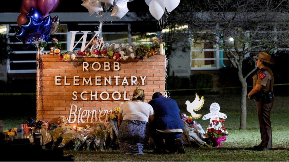 Stephanie and Michael Chavez of San Antonio pay their respects at a makeshift memorial outside Robb Elementary School,