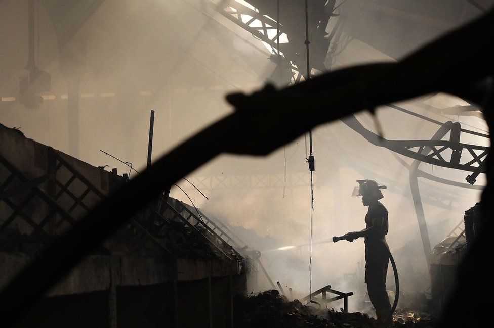 Fire fighters work to put out a blaze at Port-au-Prince's historic Iron Market.