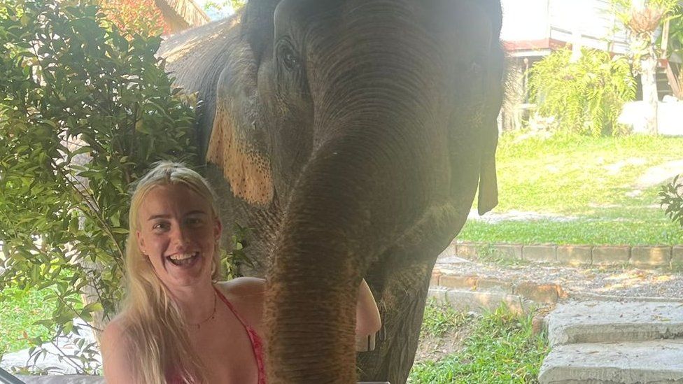 Eve Bevan holding an elephant's trunk