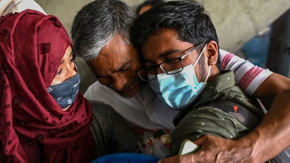 A man embraces his son who was evacuated from Ukraine after his arrival on a special flight at the airport in Chennai on February 27, 2022.