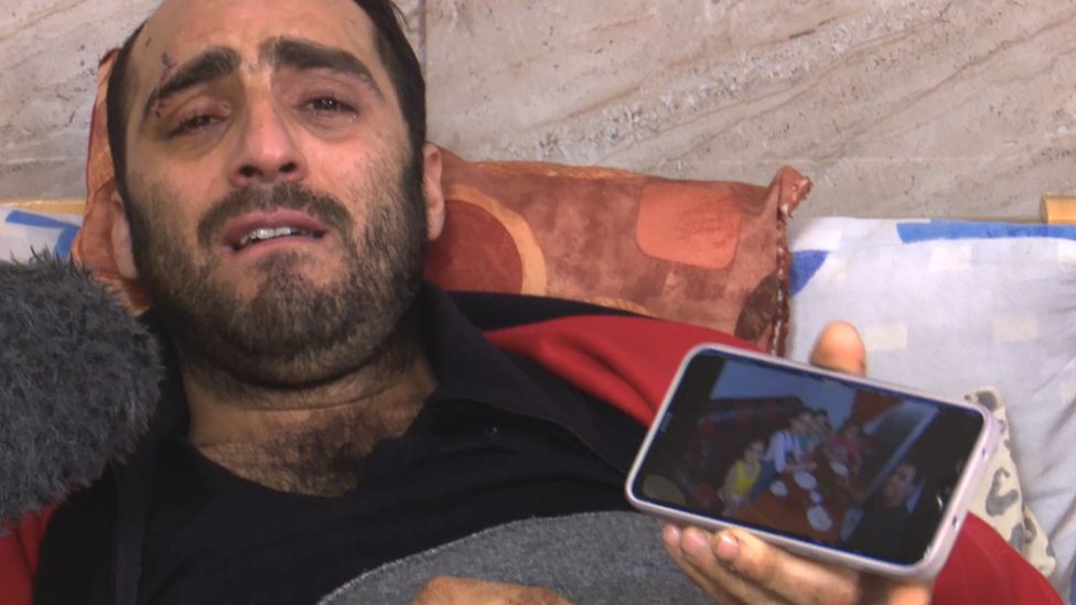 Man in hospital bed holds phone