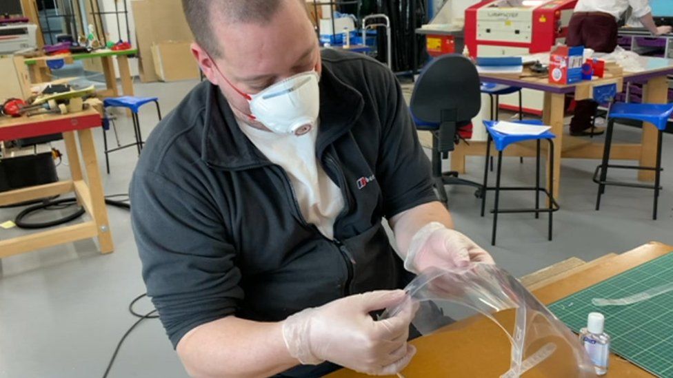 A teacher at St Benedict's High School making a visor