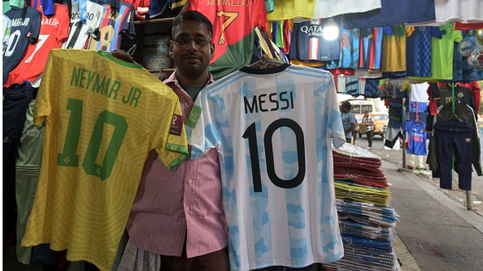 Jerseys of iconic football players like Messi, Neymar, Ronaldo and flags of Brazil, Argentina, and other nations on display for sale on at the Esplanade market ahead of Qatar Football World Cup 2022 on November 15, 2022 in Kolkata, India. (