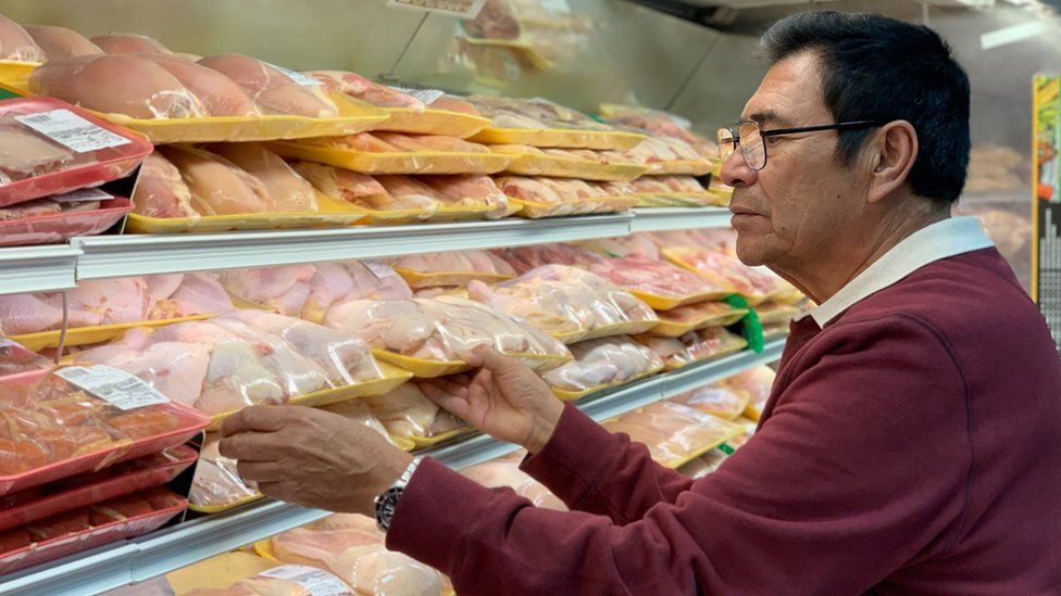 Man buying chicken at supermarket