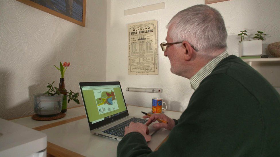 Professor Parnell at his kitchen table on Millport, looking at his laptop