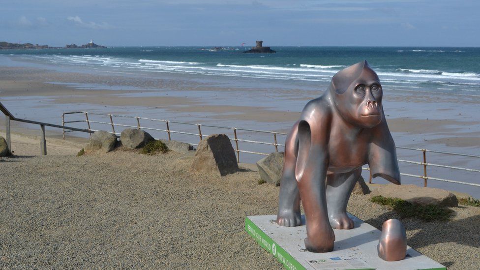 Gorilla in front of beach and tower