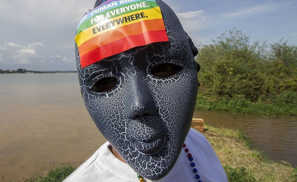 Person with a mask on and a rainbow sticker