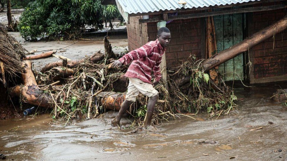 A 12-year-old boy walks through the mud after River Muruny burst its bank following heavy rains in Parua village, about 85 km northeast of Kitale, in West Pokot county, western Kenya on November 24, 2019.