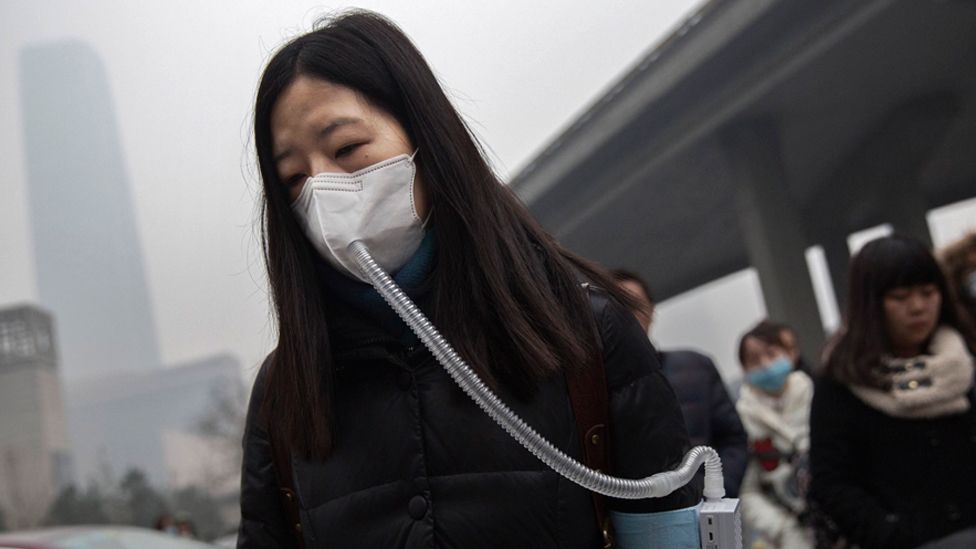 A Chinese woman wears a mask and filter as she walks to work during heavy pollution on December 9, 2015 in Beijing, China