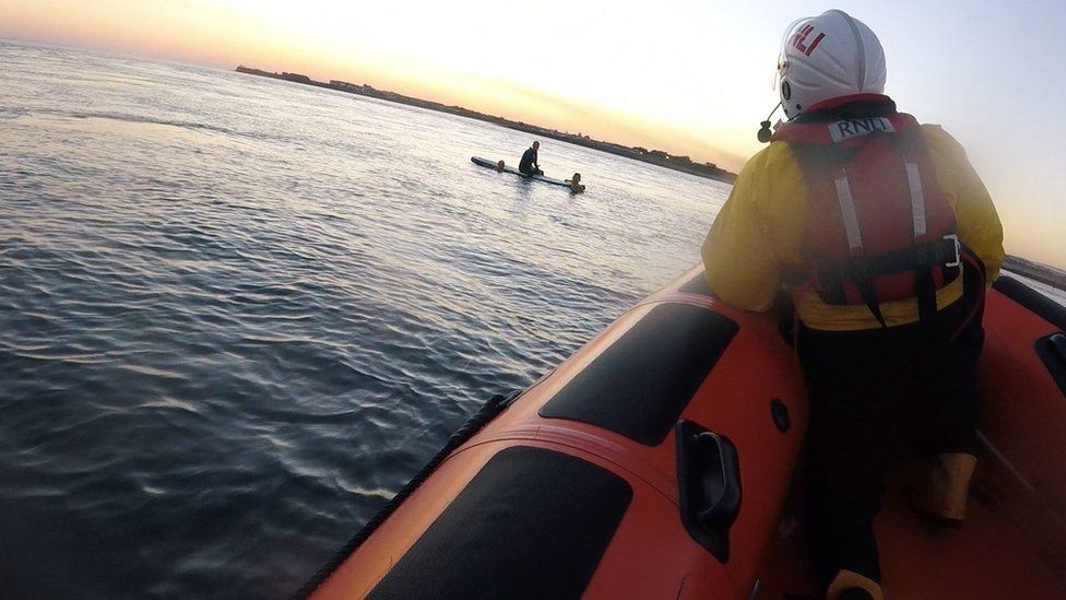 Porthcawl RNLI reaching a paddleboarder