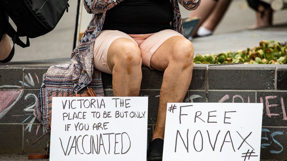 Novak Djokovic supporter displays anti-vaccination signage as they gather outside Park Hotel where Djokovic was taken pending his removal from the country after his visa was cancelled by the Australian Border Force on January 06, 2022 in Melbourne, Australia.