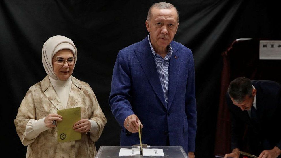 Turkey's President and presidential candidate of AK Party Recep Tayyip Erdogan (R), flanked by his wife Emine Erdogan (L), casts his ballot on the day of the Presidential runoff