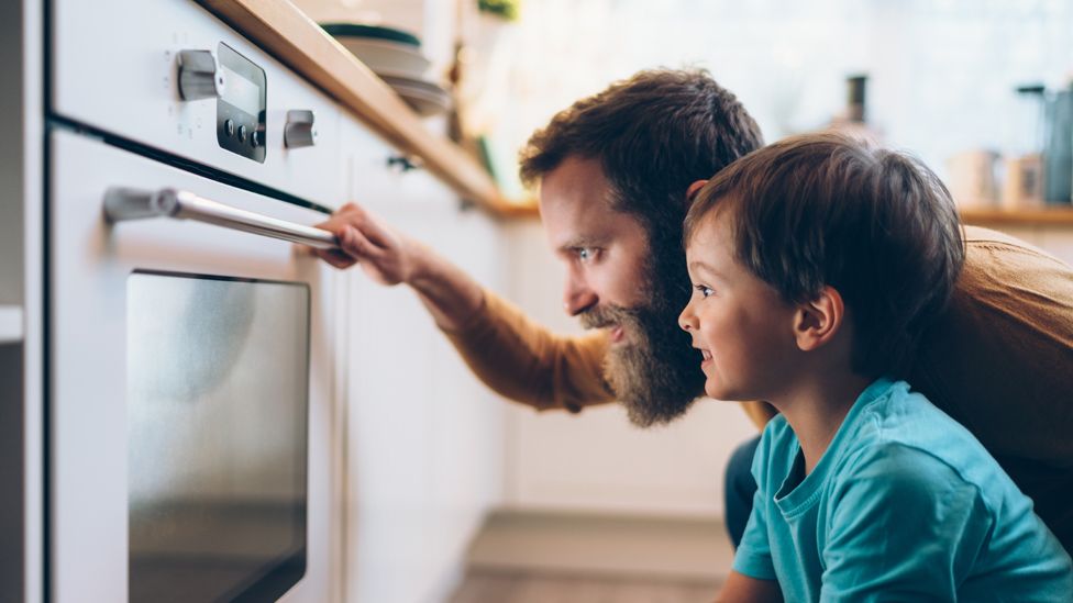 Мужчина и мальчик смотрят на духовку — стоковый снимок
