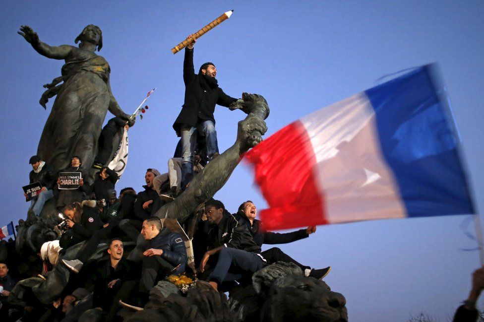 A man holds a giant pencil as he takes part in a solidarity march in the streets of Paris after the Charlie Hebdo shootings, France, 11 January 2015