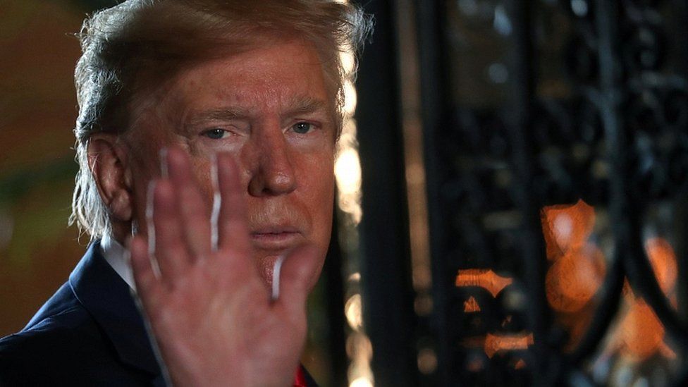 President Donald Trump waves to the media after participating in a video teleconference with members of the US military at Trump's Mar-a-Lago resort in Palm Beach, Florida, U.S., December 24, 2019