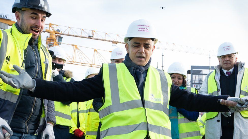 Mayor of London Sadiq Khan tries his hand at bricklaying during the topping out ceremony of a new affordable housing development in the Royal Docks