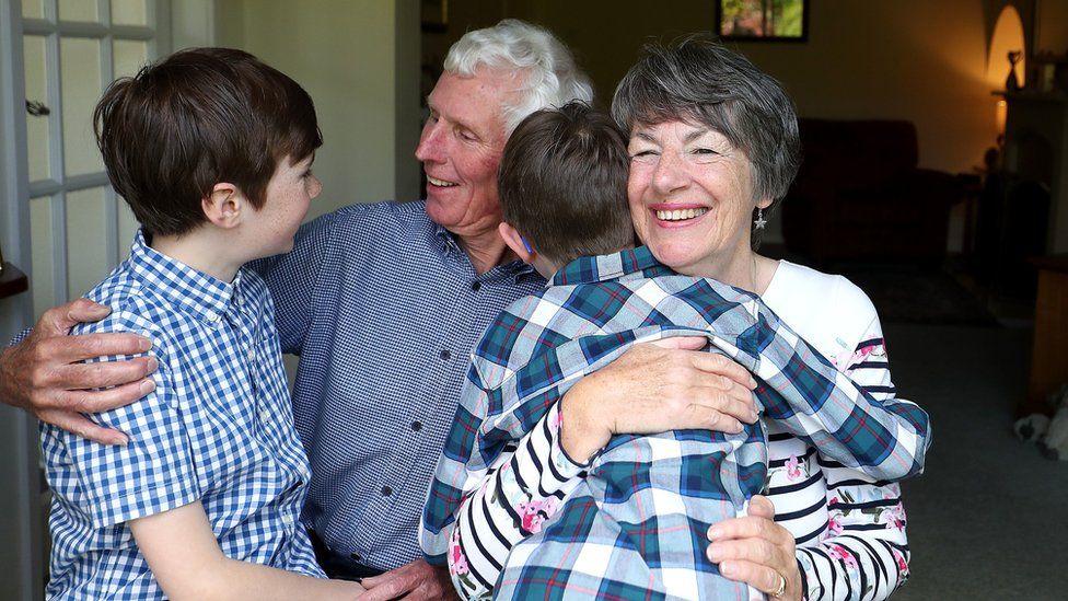 Sue and Alan Rickett hug their grandchildren Ben (left) and Isaac (right) for the first time in over a year, in anticipation of lockdown restrictions being eased in England.