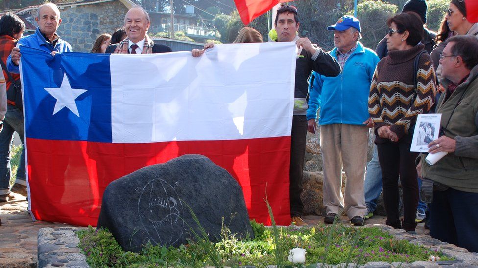 Rodolfo Reyes and others hold up a Chilean flag at the reburial of Pablo Neruda following his exhumation