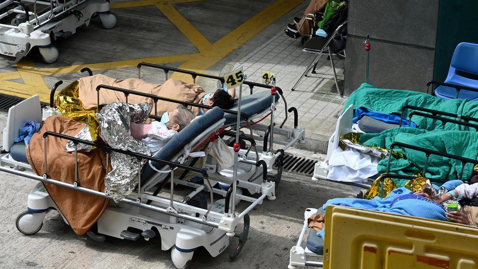People lie in hospital beds outside the Caritas Medical Centre in Hong Kong