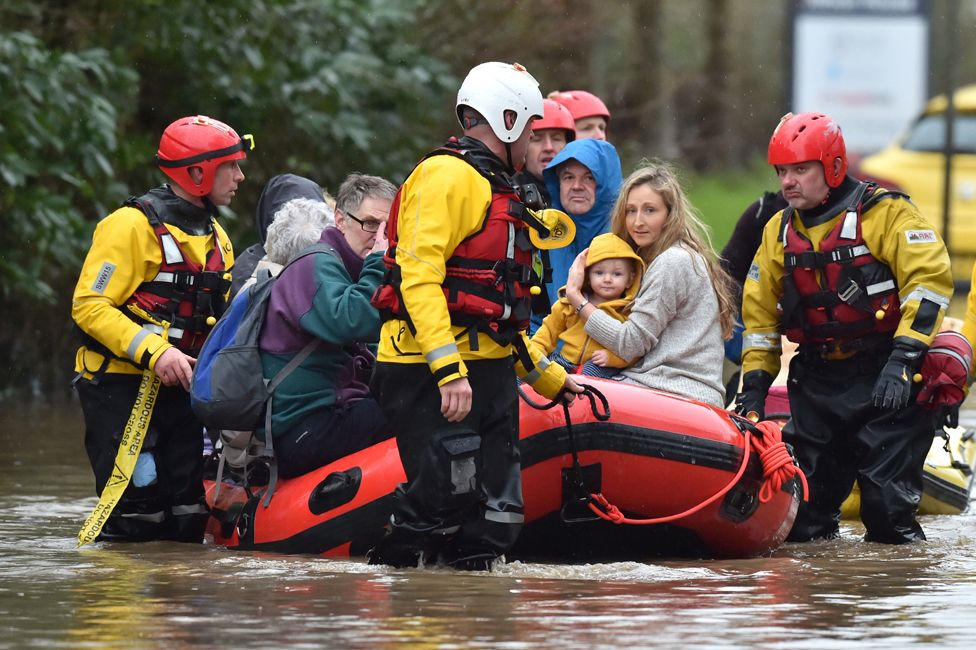 Residents of Nantgarw in a rescue boat as emergency services take people to safety, after flooding in the village in Wales